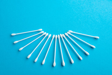 Cotton ear swabs sticks on blue background. close up. Image with selective focus, noise effect and toning. Top view. Flat lay.