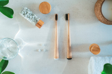Top view zero waste bathroom items. Bamboo toothbrushes, natural mouthwashing tabs, fresh green...