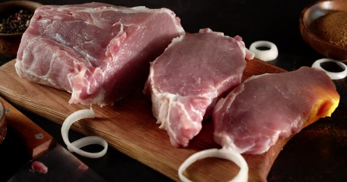 Sliced chunks of raw pork escalope slowly rotate. 
