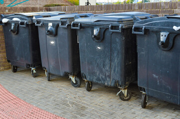 garbage containers are in the city. black capacious containers for storing various garbage in the city center. separate collection of secondary waste and repair products