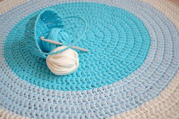 Fototapeta na wymiar Round knitted rug made of blue and white yarn.Handmade work.