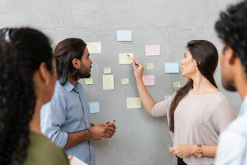 Professional latin business coworkers discussing sales strategy and planning in co-working open...