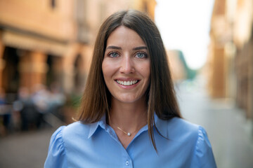 Authentic shot of an young carefree happy woman is smiling in camera in old city center on a sunny day.