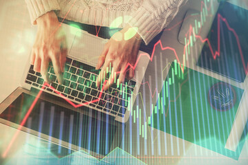 Double exposure of woman hands working on computer and forex chart hologram drawing. Top View. Financial analysis concept.