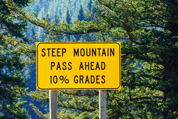 Steep mountain pass traffic warning sign advising motorists of a steep ten percent mountain grade...