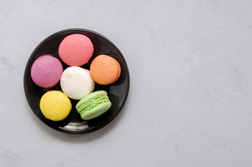 Colourful macaroons on the glass plate close up