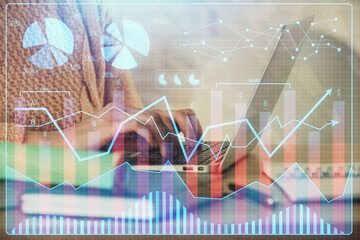 Double exposure of woman hands typing on computer and forex chart hologram drawing. Stock market analysis concept.