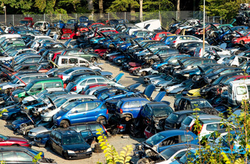 Old rusty corroded cars in car scrapyard. Car recycling in Germany