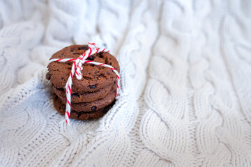 Stack of tasty chocolate christmas cookies on light coloured background. Blue cup mug. Image with selective focus, noise effect and toning. Top view.