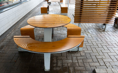 Round light brown table, outdoor roadside cafe on an autumn day