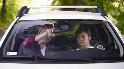 Caring parent teaching his son how to drive car. Father passes on knowledge to teenage son. Man and teen boy spending time together, family.