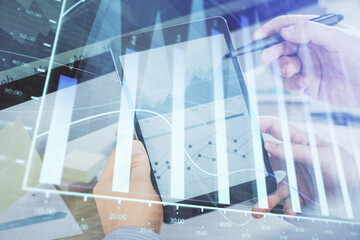 Double exposure of man's hands holding and using a phone and financial chart drawing. Market analysis concept.