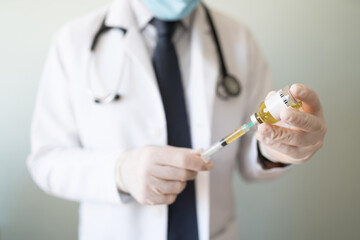 Doctor holding a syringe and vaccine in a studio