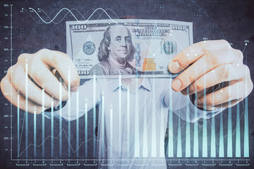 Multi exposure of financial graph drawing hologram and USA dollars bills and man hands. Analysis concept.