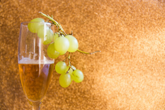 Vaso y uvas  sobre fondo marr&oacute;n.