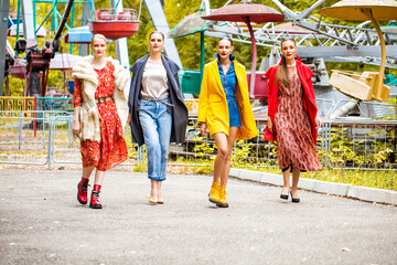 Fototapeta premium Four fashion models walking in autumn park