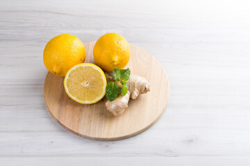 Fresh sicilian lemon slice with ginger on a white wooden background