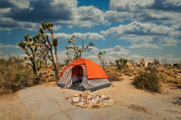 This image shows the side view of an empty camping tent in the middle of a remote desert landscape.