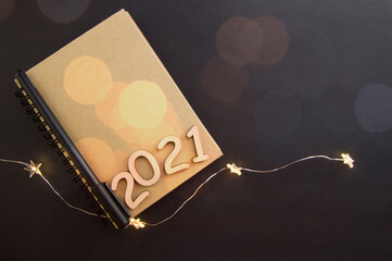 notebook for 2021 and pen lie on black background.new year 2021