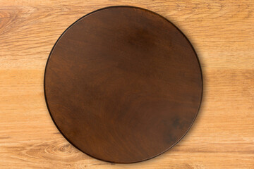 Circular wooden cutting kitchen Board, isolated on wooden table background. Top view