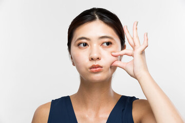 頬をつまむ女性