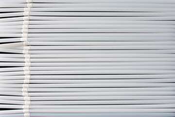 top view of white  plastic drinking  straws in a row