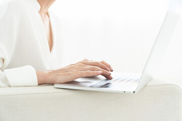 Naklejka premium ラップトップコンピューターを見るシニア女性 手元