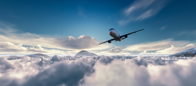 Airplane is flying above clouds at sunset