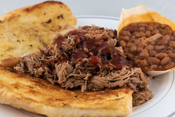 BBQ meal of pulled pork, baked beans, and butter toasted bread will taste as delicious as it looks.