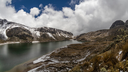 Fototapeta premium Lagoon located in the Los Nevados National Natural Park in Colombia, with a bottom of rocks with ice.
