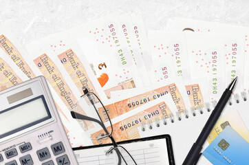 10 British pounds bills and calculator with glasses and pen. Tax payment concept or investment...