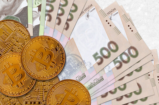 500 Ukrainian hryvnias bills and golden bitcoins. Cryptocurrency investment concept. Crypto mining or trading
