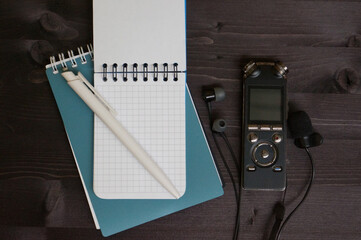 Journalist or blogger digital voice recorder or dictaphone and notepad with pen on desk