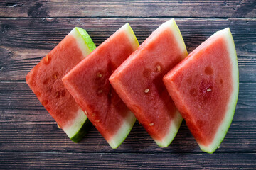 sliced watermelon fruit sitting on a wood background