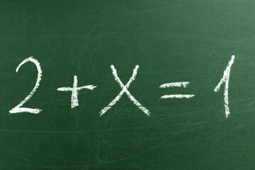 Tricky math equation on the green School blackboard. Handwriting simple mathematical equations....