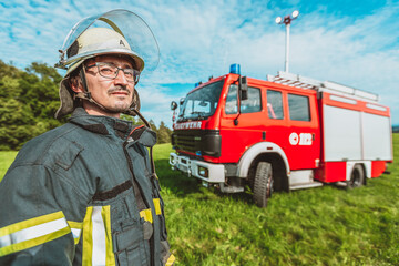 A german fireman stands near a firetruck