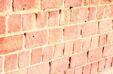 Fototapeta premium Background of old, slightly damaged bricks. Brick wall at an angle. The surface of the building structure.