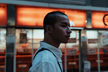 Skin head asian office worker walking on street at night.