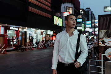 Skin head asian worker man walking on street looking for food in evening.