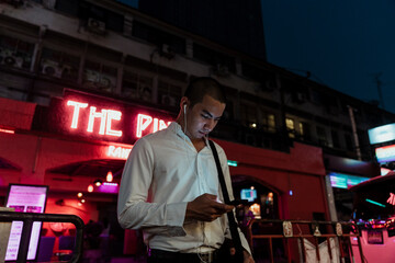 Business man listen to music with earphone at night.