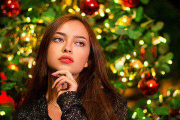 retrato de mujer a la moda en navidad, joven con árbol de navidad, retrato navideño, moda navideña, mujer de cabello castaño y ojos claros.