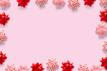 Fototapeta na wymiar Christmas composition. Christmas gift, knitted blanket, pine cones, fir branches on pink background. Flat lay, top view, copy space