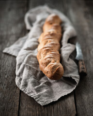Freshly baked french baguette on the old wooden table. Selective focus. Shallow depth of field.