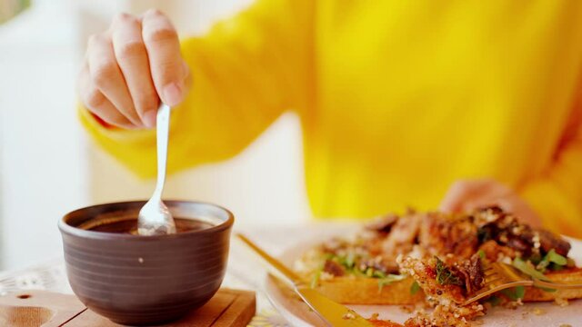Woman hold a spoon and stirring hot coffee on white table, in a caf&egrave; 
