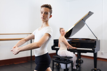 Fototapeta na wymiar Ballet lesson in the studio. Choreographer plays the piano. High quality photo