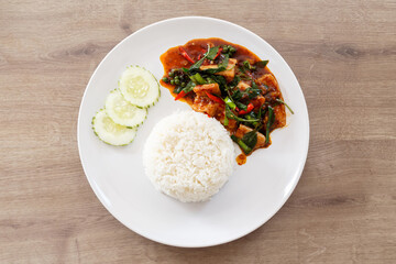 Top view Thai curry with steamed rice on white dish.