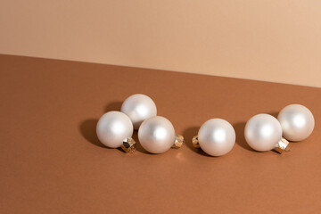 White christmas balls isolated on beige background. Christmas concept. Horizontal photo. Flat lay. Idea for decoration.