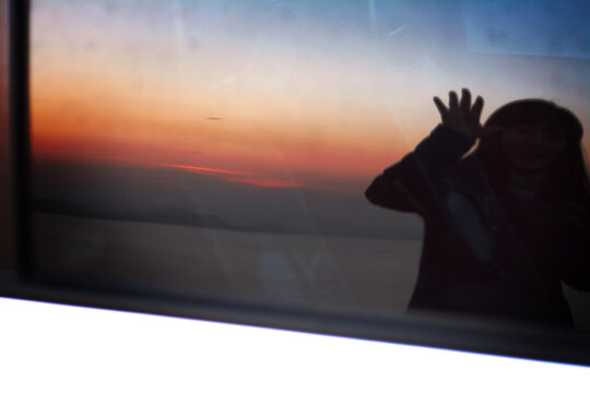 The image of you reflected in the glass window at sunset
