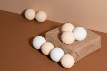 The soft fragrant bath salt bombs are on the paper box isolated on beige background. Idea for bathroom.