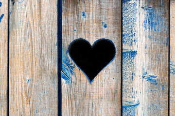         A silhouette of a heart carved in a chalkboard a door or fence.